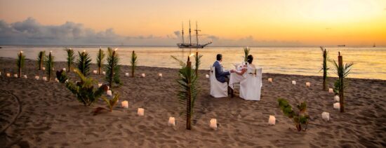 wedding dinner on beach with ship in background